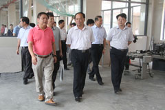 遂溪县委书记、县人大主任林少明（第一排中）在廉江市委常委、常务副市长李世东（第二排右一），市委常委袁汉荣（第一排右一），学院董事长宣承志（第一排左一）的陪同下参观学院